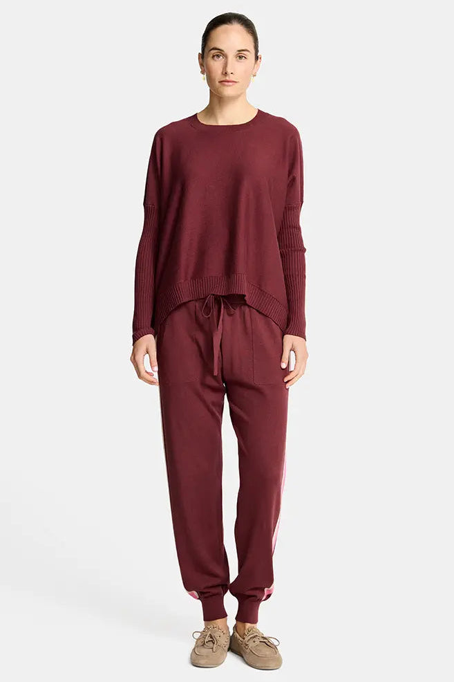 Person wearing a burgundy loungewear set on a white background