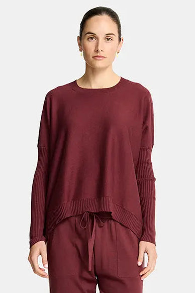 Person wearing a burgundy loungewear set on a white background