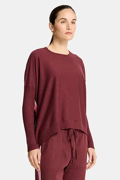 Person wearing a burgundy outfit with a white background