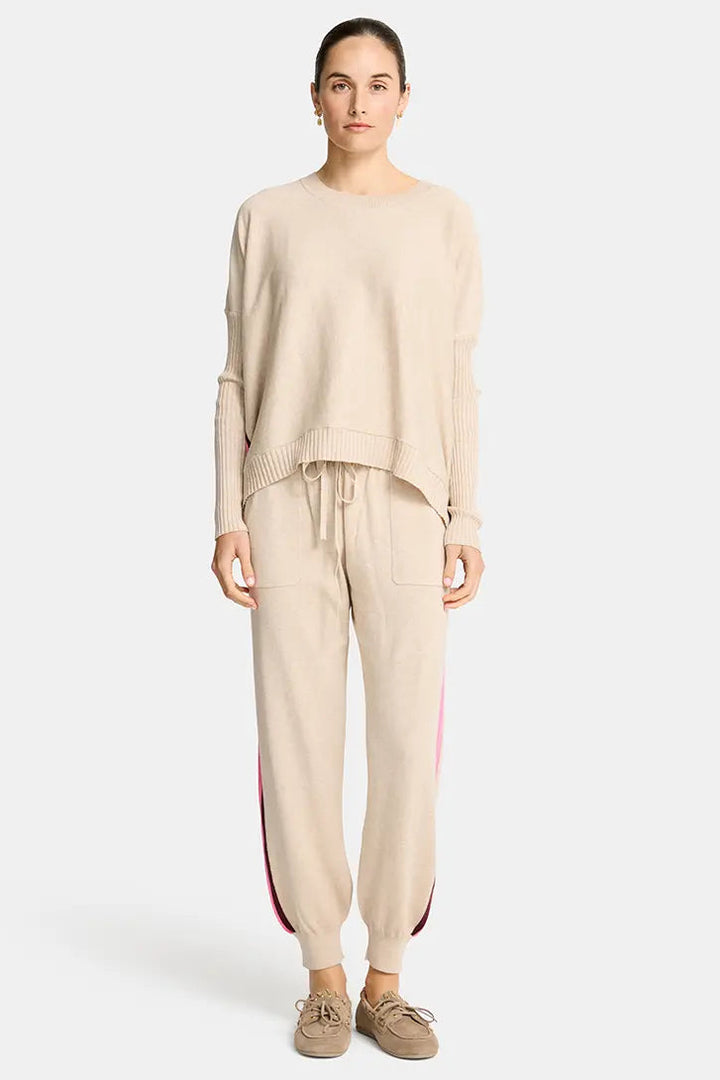 Woman wearing a beige outfit with a plain background