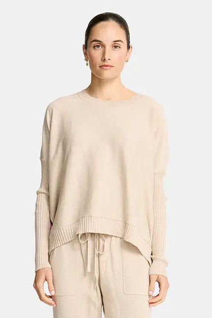 Woman wearing a beige outfit with a plain background