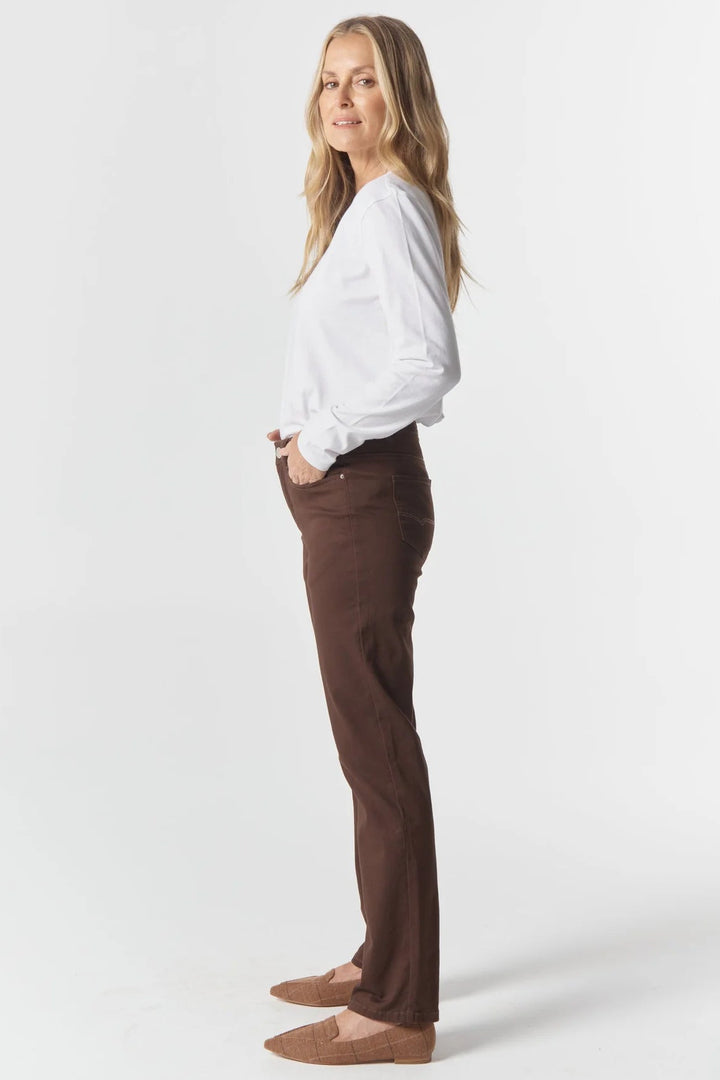 Woman wearing a white blouse and brown pants on a white background