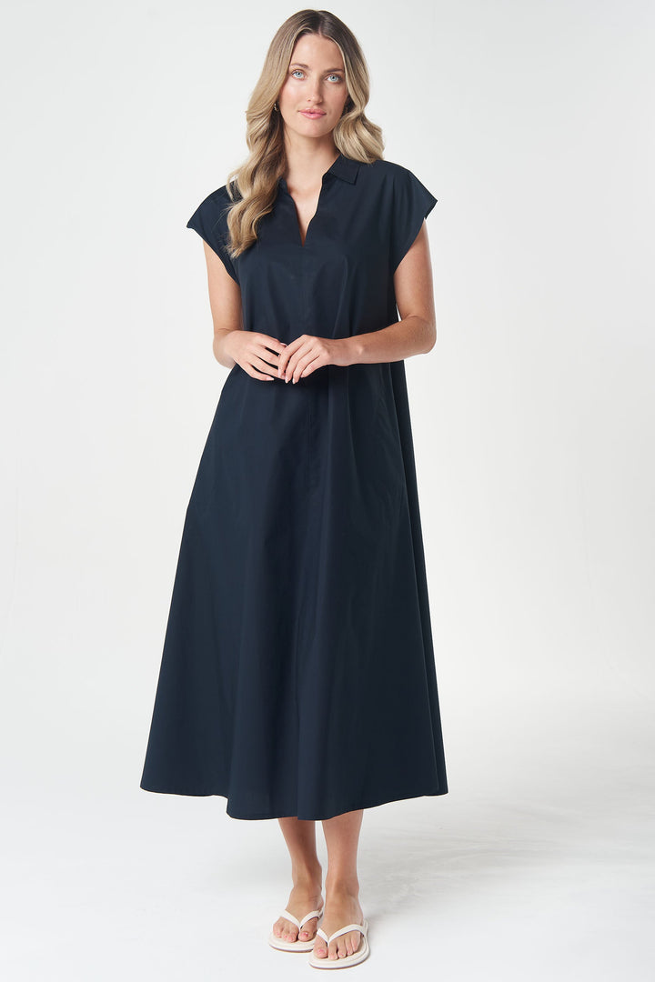 A woman modeling a dark navy midi dress with cap sleeves and a split neckline, standing against a light gray studio background.