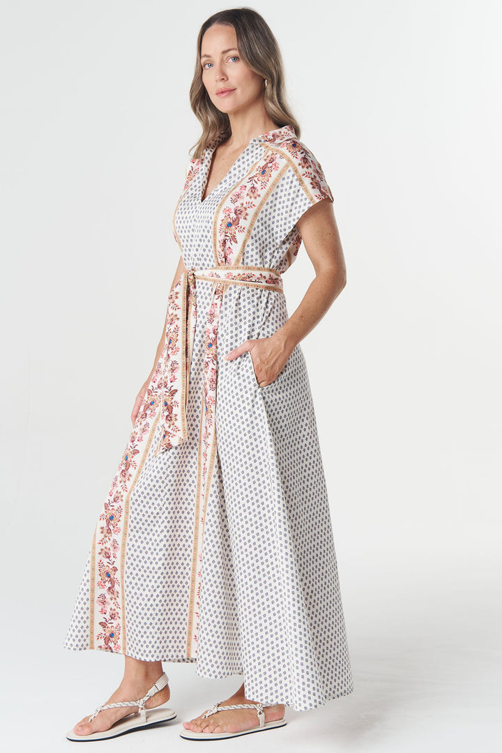 Woman wearing a patterned dress with a belt on a white background