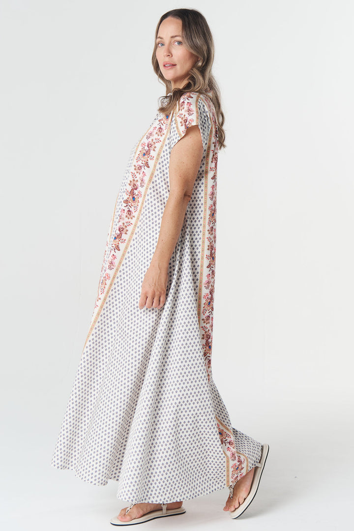 Woman wearing a long, patterned dress on a white background