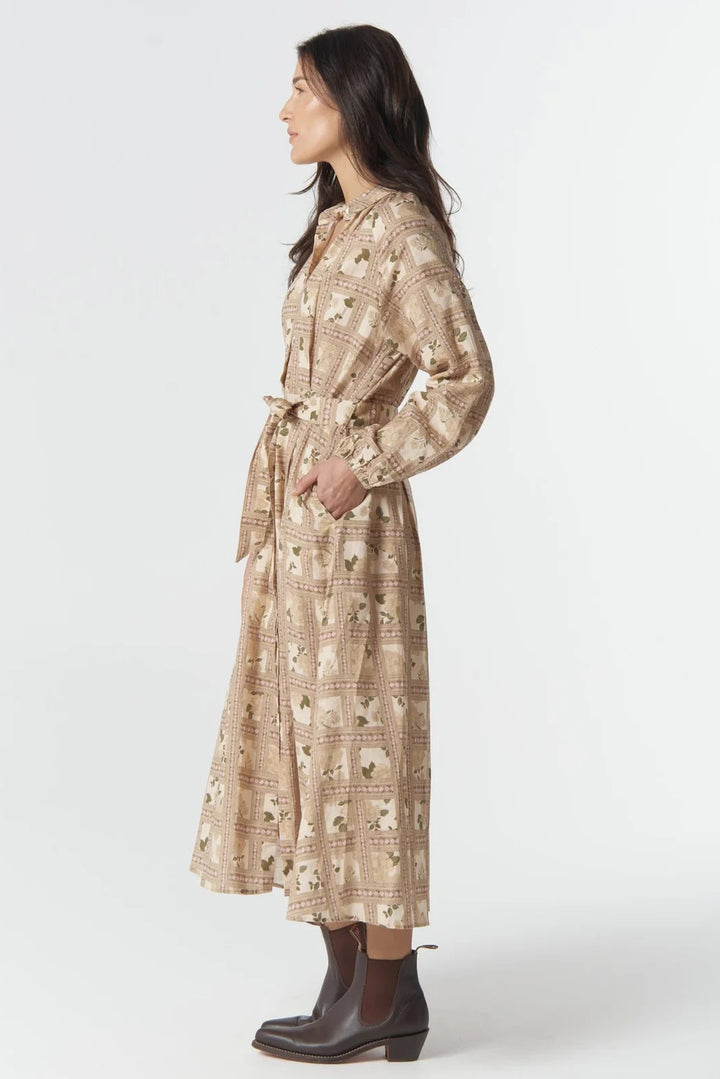 Woman wearing a floral dress with a belt on a white background