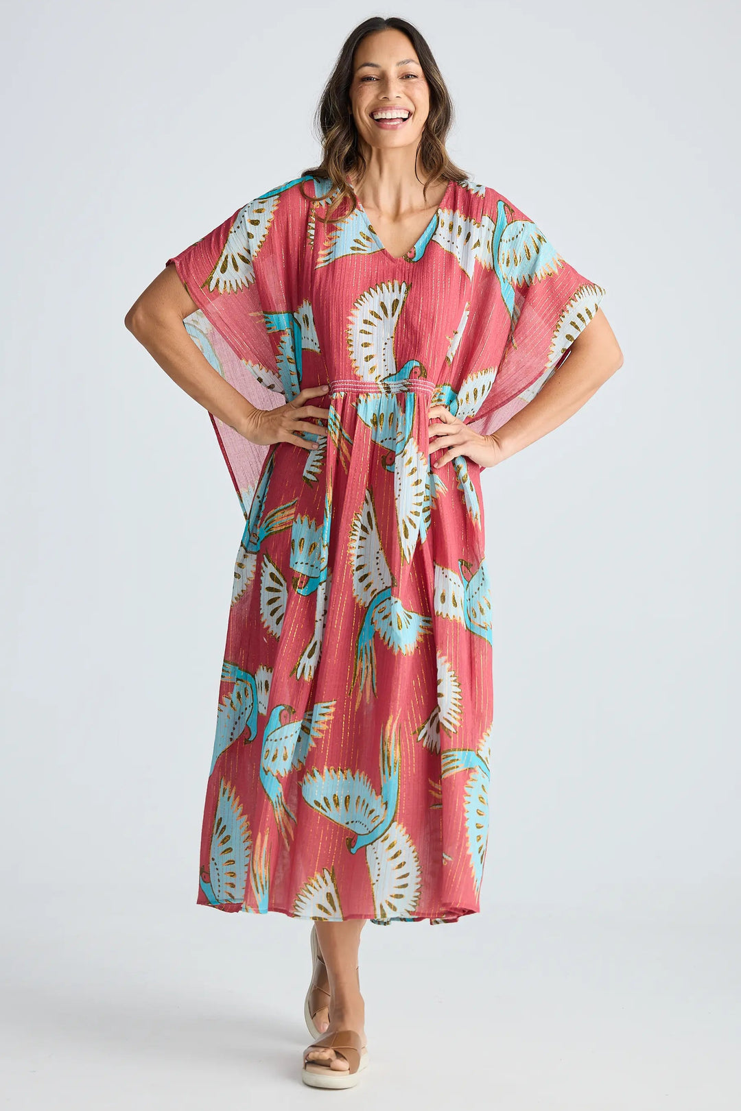 Woman wearing a pink floral dress on a white background. Holiday Trading Lorrini Kaftan Red Macaw