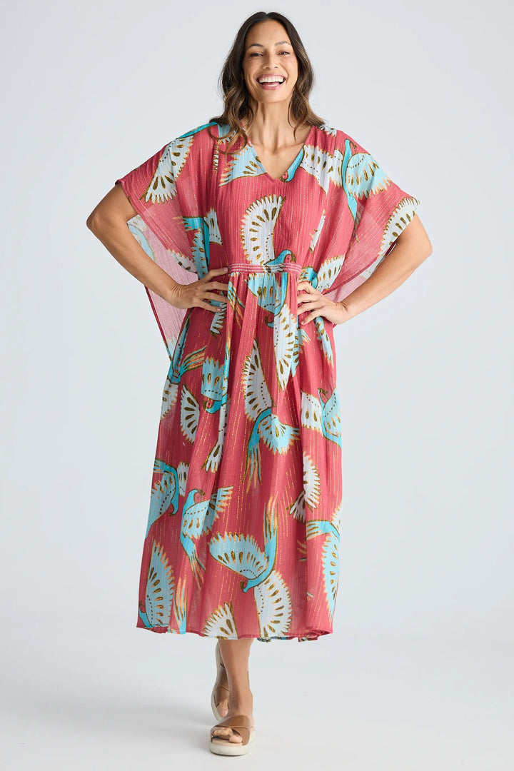 Woman wearing a pink floral dress on a white background. Holiday Trading Lorrini Kaftan Red Macaw