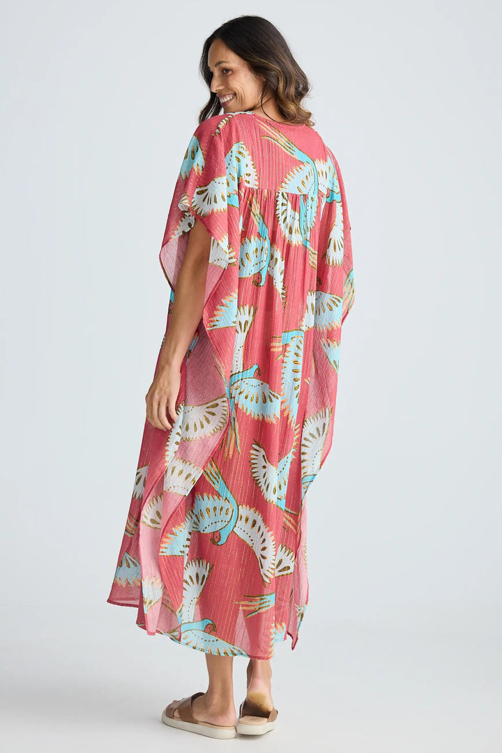 Woman wearing a pink floral dress on a white background. Holiday Trading Lorrini Kaftan Red Macaw