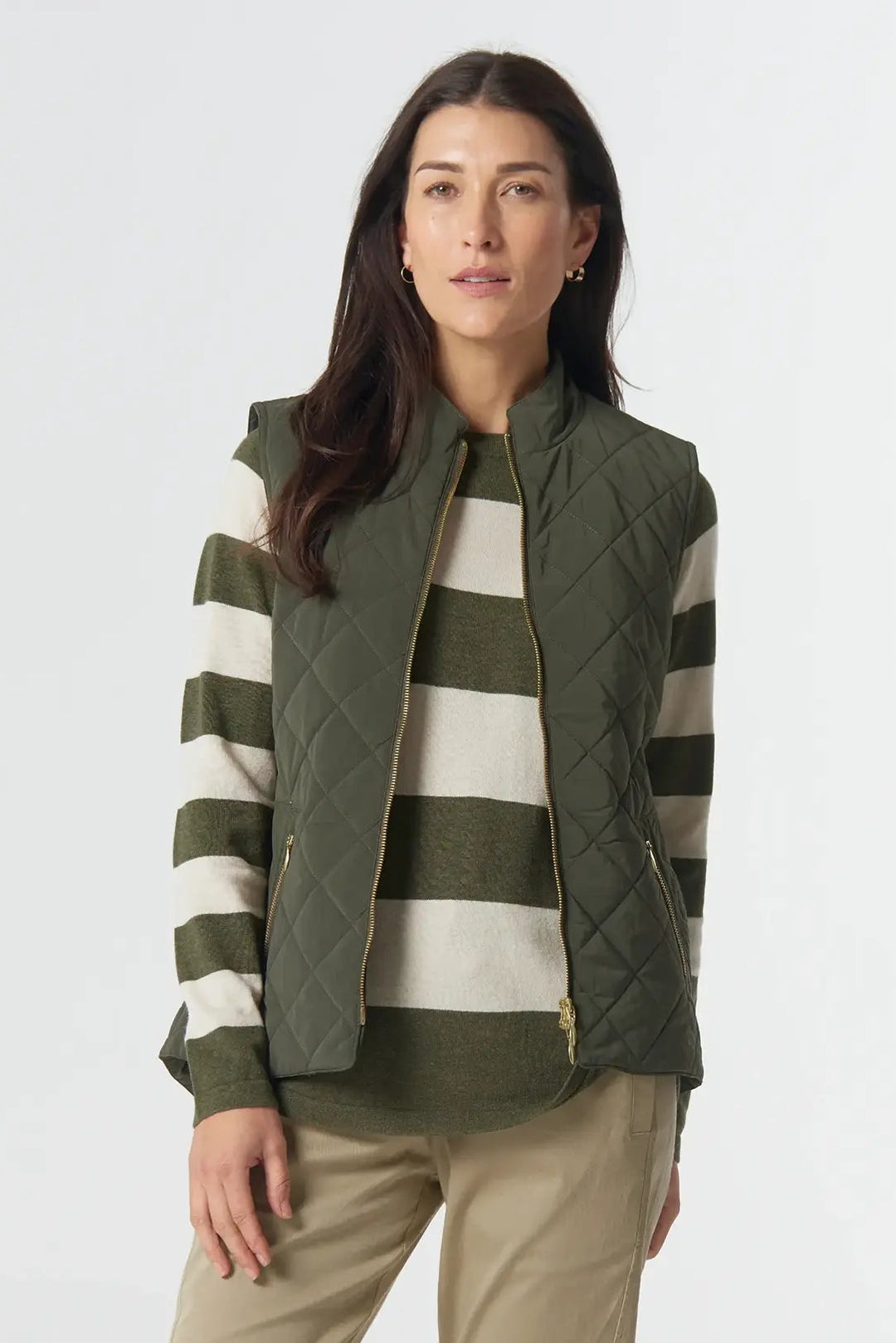 Woman wearing a striped sweater and green vest on a white background