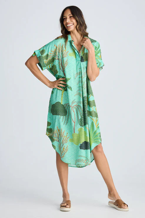 Woman wearing a green patterned dress on a white background. Holiday Trading Canal Overshirt Rainforest Print