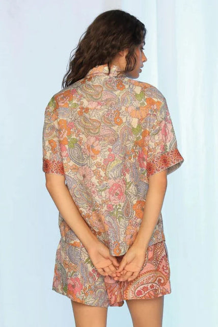 Woman wearing a patterned dress standing against a white background. Kachel Isla Shirt