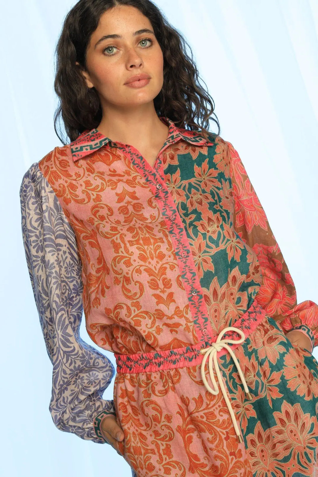 Woman wearing a colorful patterned outfit on a light blue background
