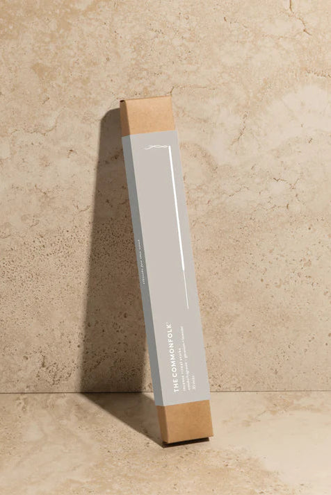 Rectangular product packaging with wooden top and bottom on a beige stone background