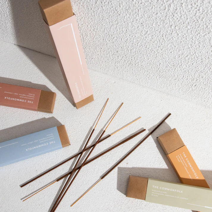 Reed diffusers and packaging on a textured white surface