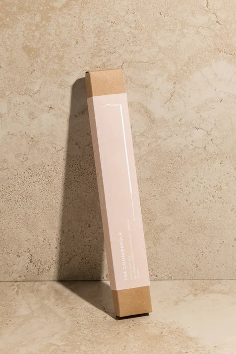 Tall rectangular box with a reflective surface against a beige stone wall.