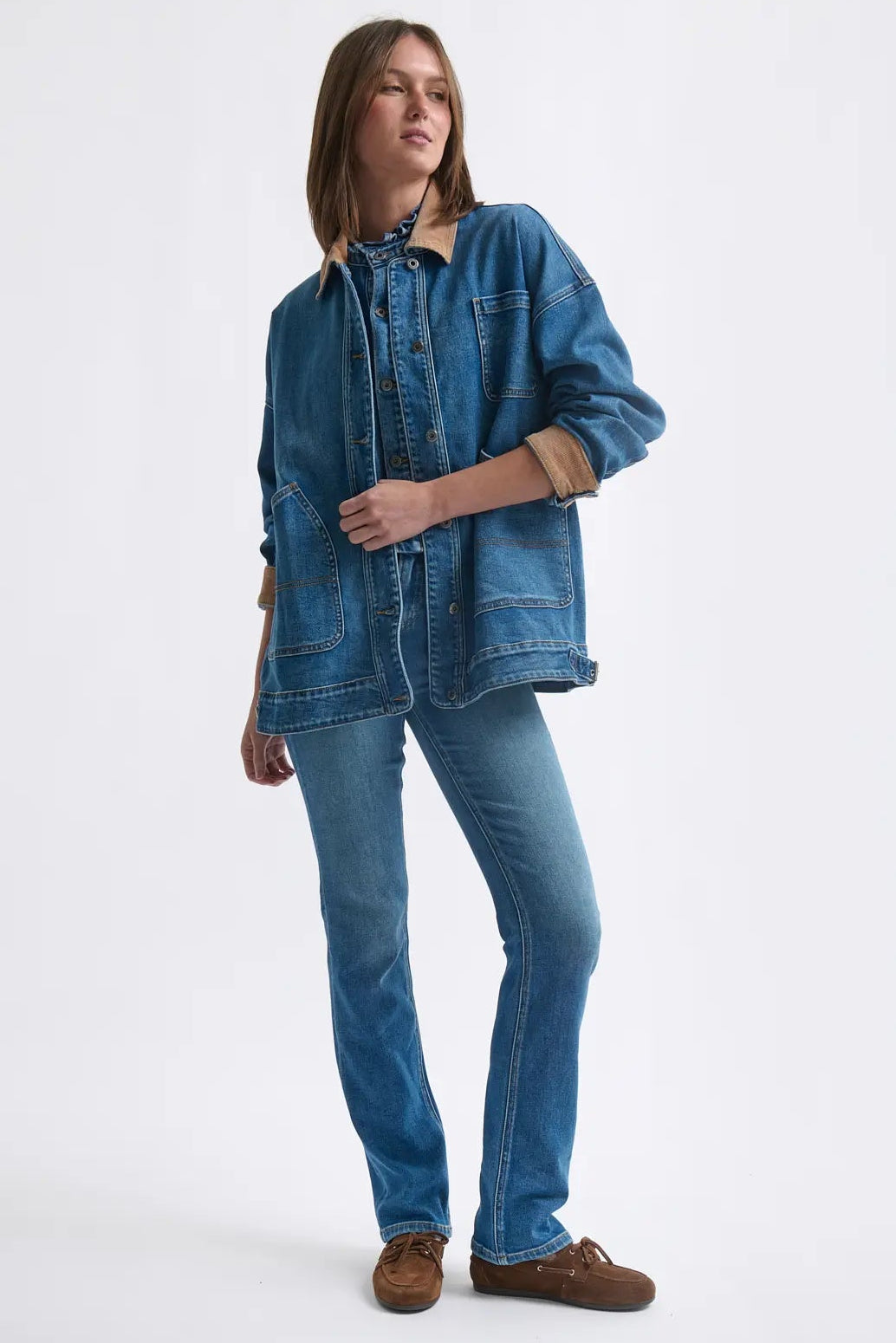 Woman wearing a denim jacket and jeans on a white background
