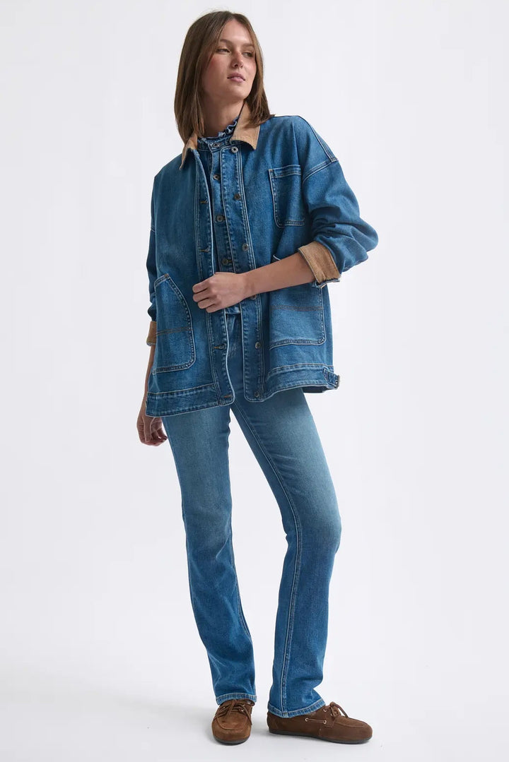 Woman wearing a denim jacket and jeans on a white background