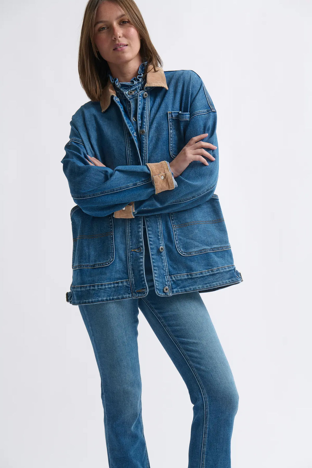 Woman wearing a blue denim jacket and jeans on a white background