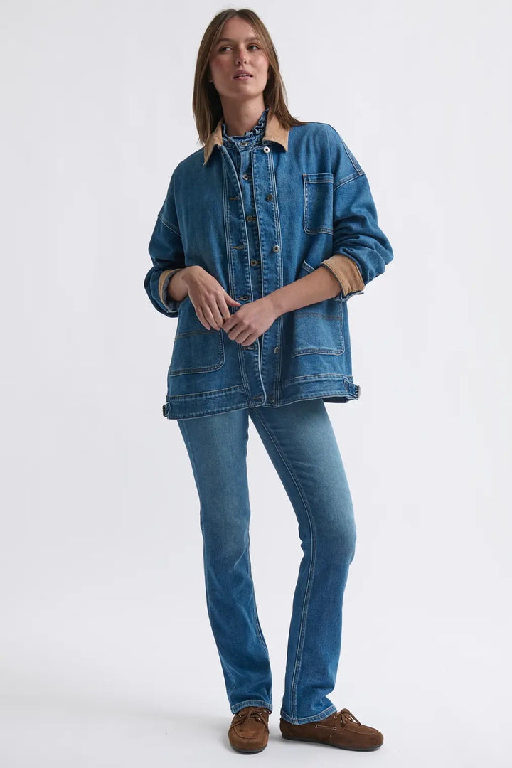 Person wearing a denim jacket and jeans on a white background