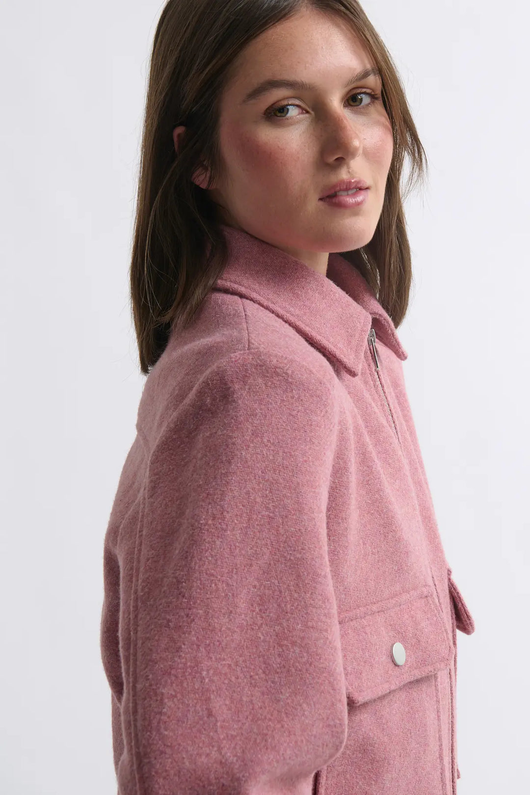 Woman wearing a pink coat on a white background