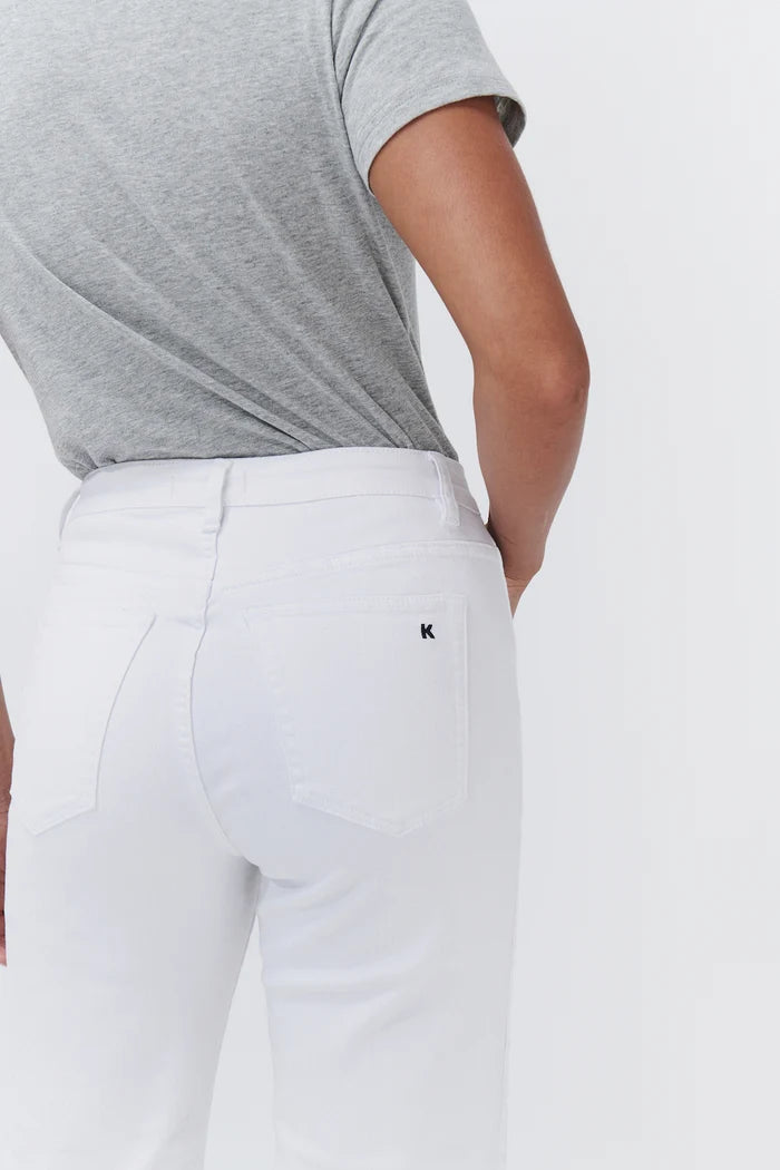 White denim jeans with a small black embroidered logo on the back pocket, worn by a model in a grey t-shirt against a white background.