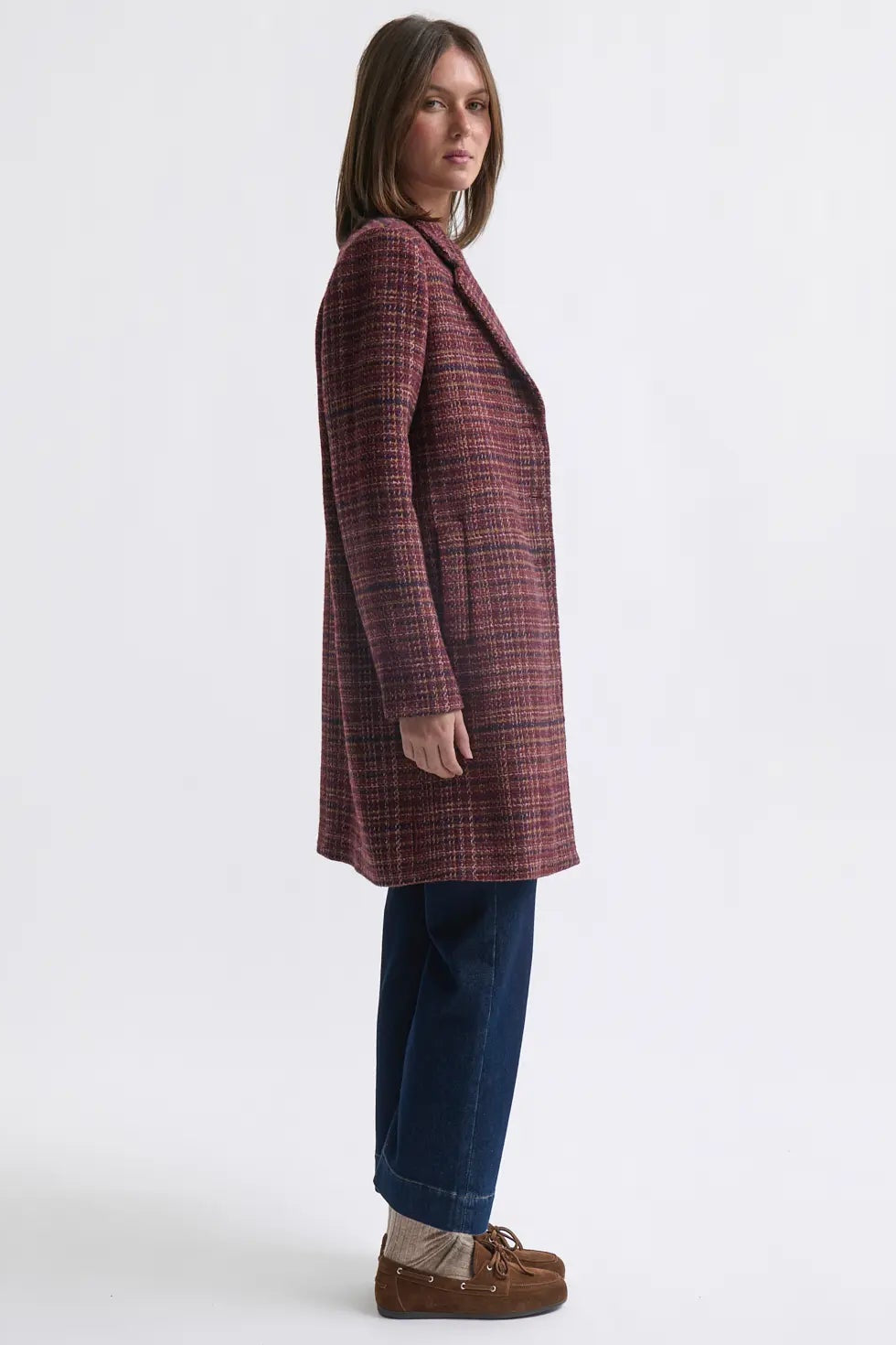 Woman wearing a plaid coat on a white background