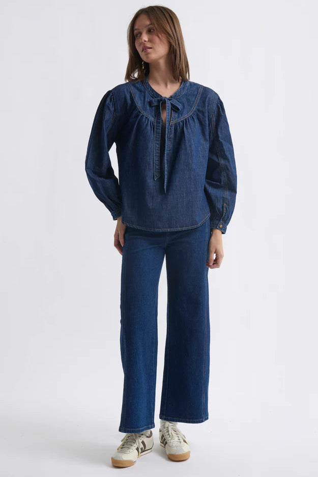 Woman wearing a blue denim outfit on a white background