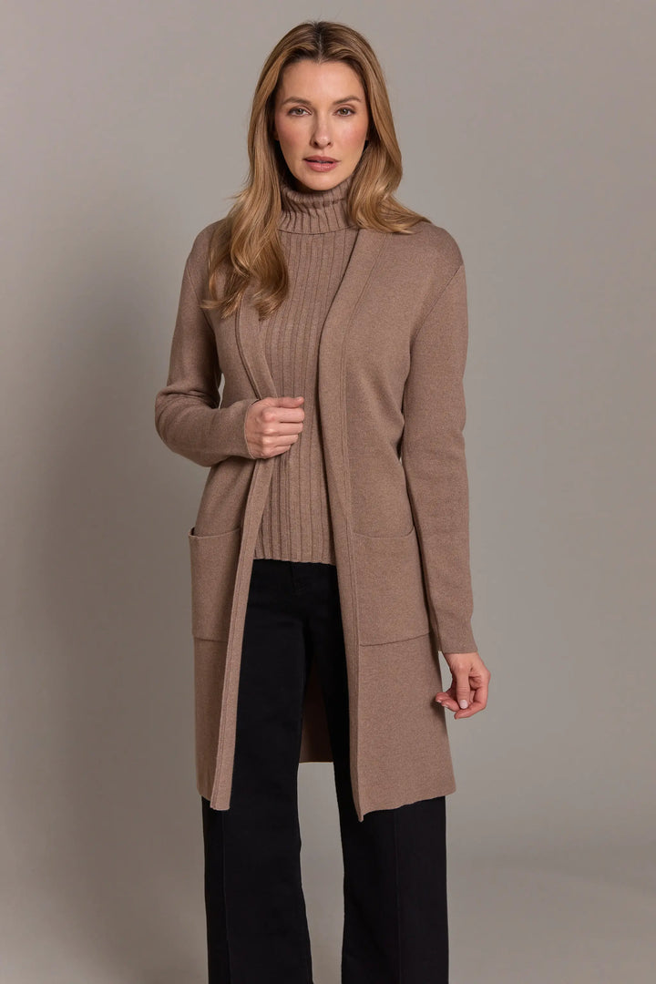 Woman wearing a long brown cardigan against a plain background