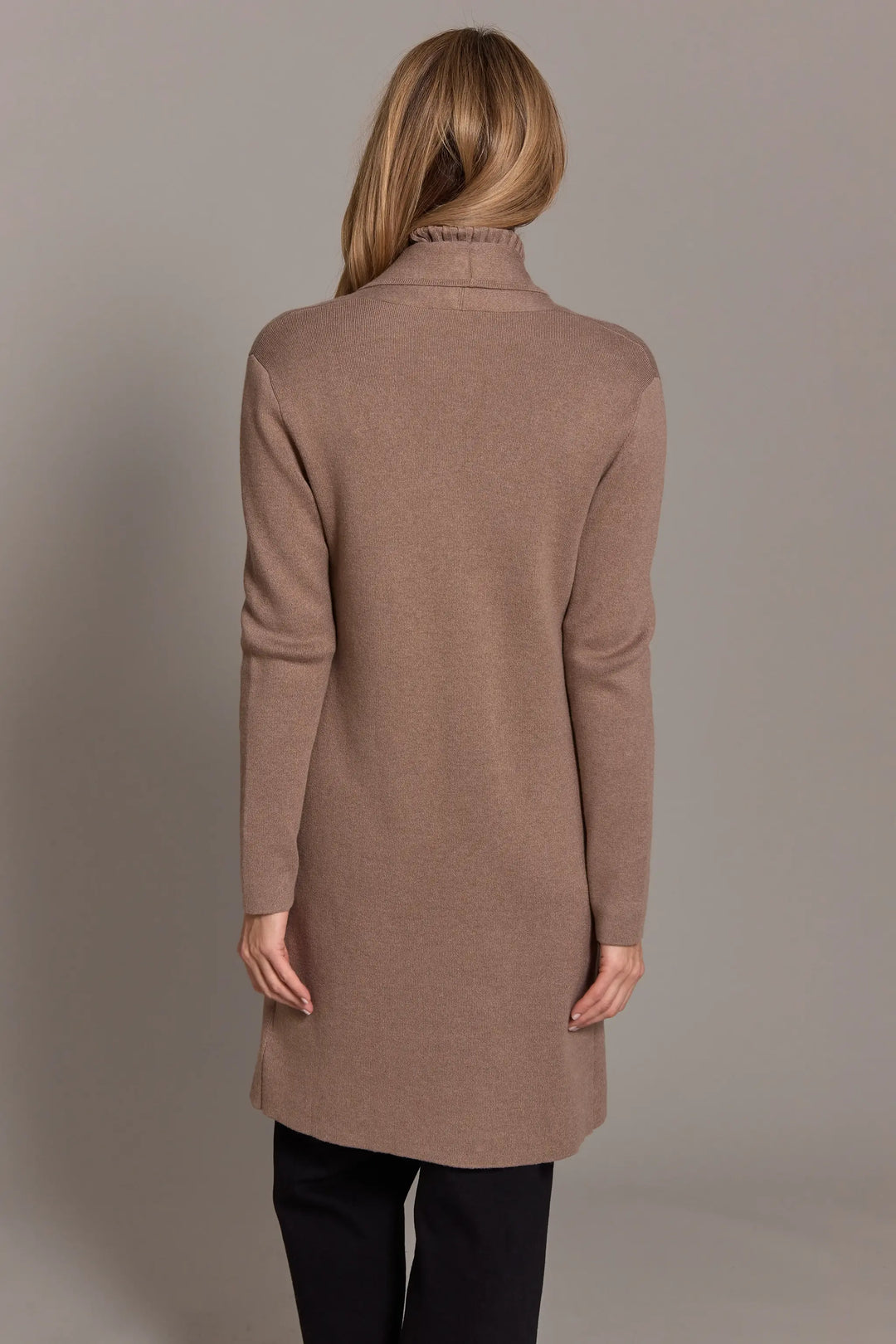 Woman wearing a brown coat against a plain background