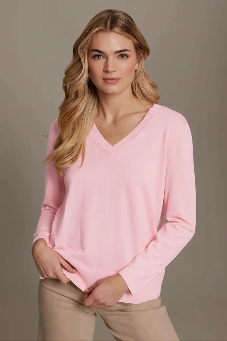 Woman wearing a pink sweater against a beige background