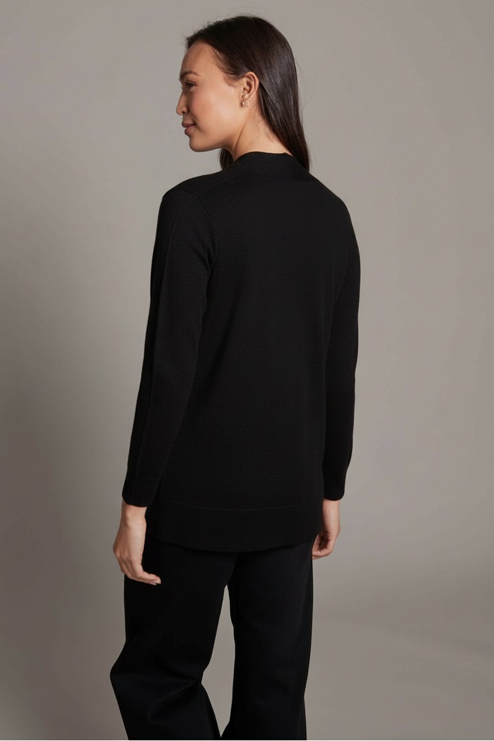 Person wearing a black long-sleeve top and black pants against a gray background