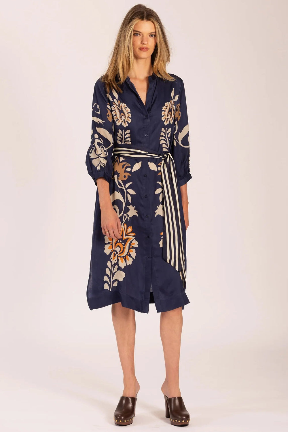 Woman wearing a navy floral dress on a white background