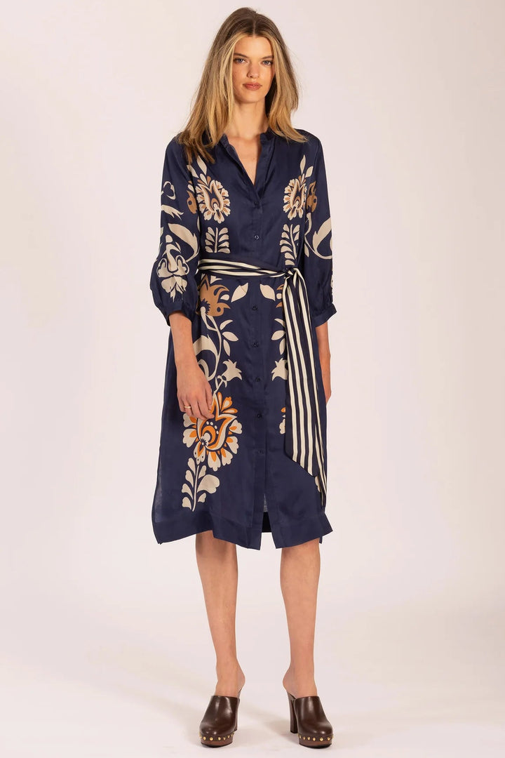 Woman wearing a navy floral dress on a white background