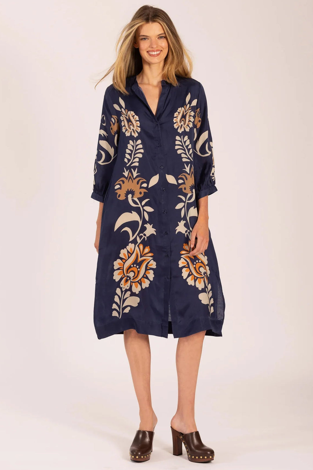 Woman wearing a navy dress with floral patterns on a white background