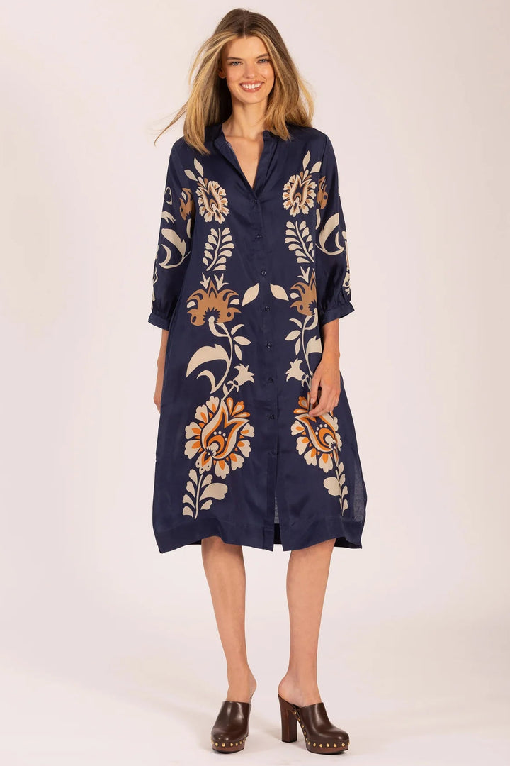 Woman wearing a navy dress with floral patterns on a white background