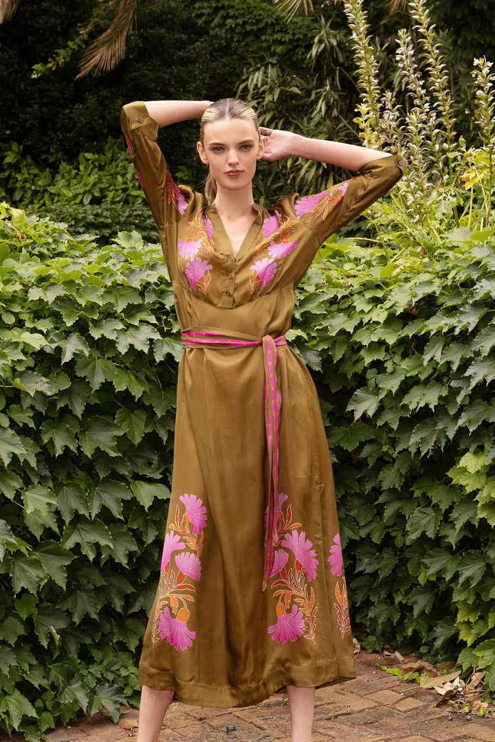 Woman in a floral dress standing among greenery