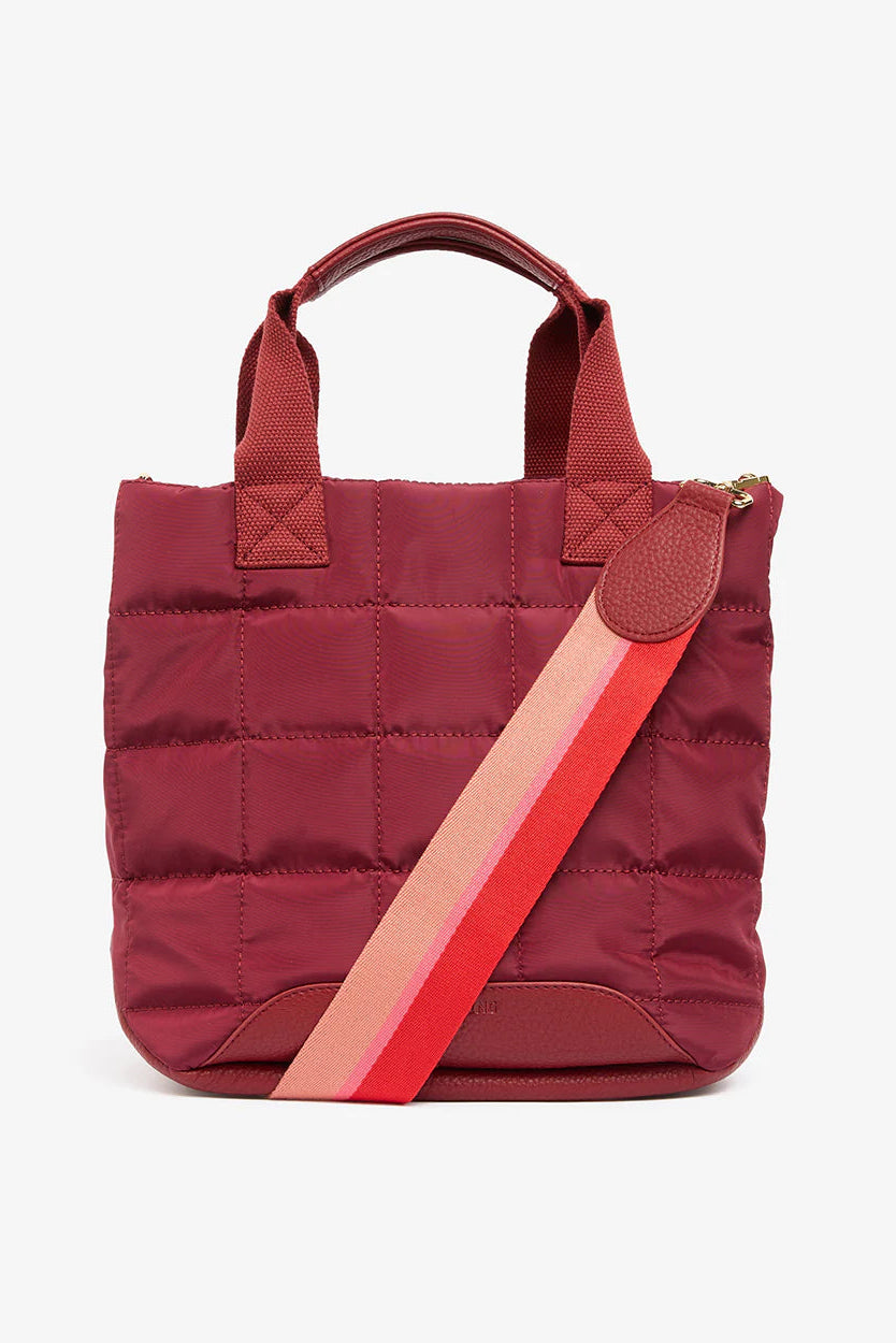 Burgundy quilted handbag with a strap on a white background