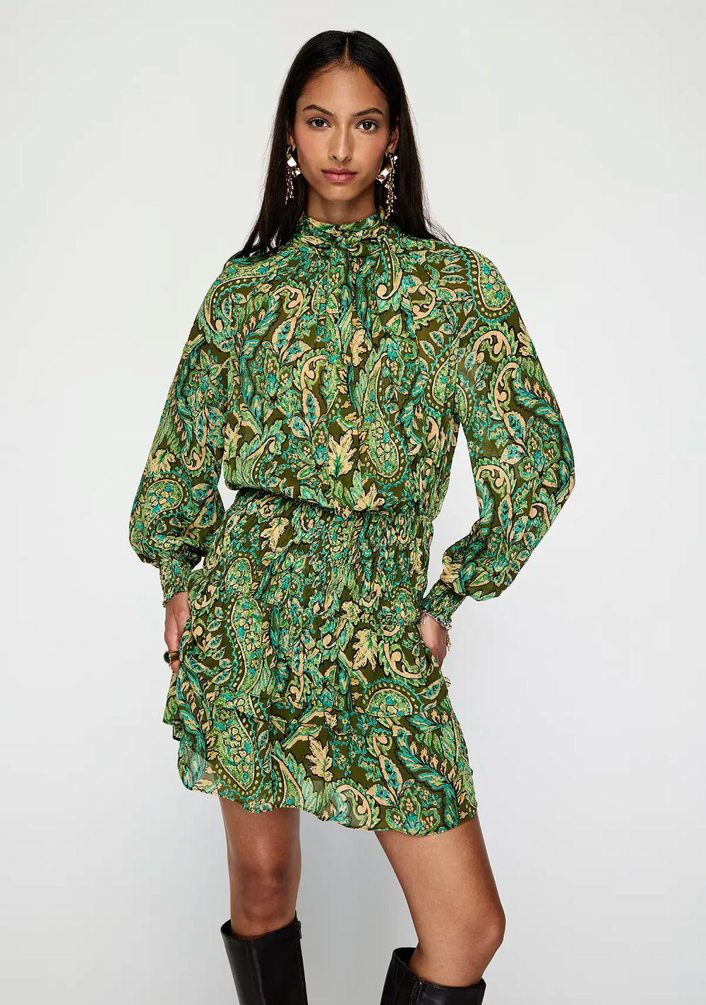 Woman wearing a green patterned dress on a white background