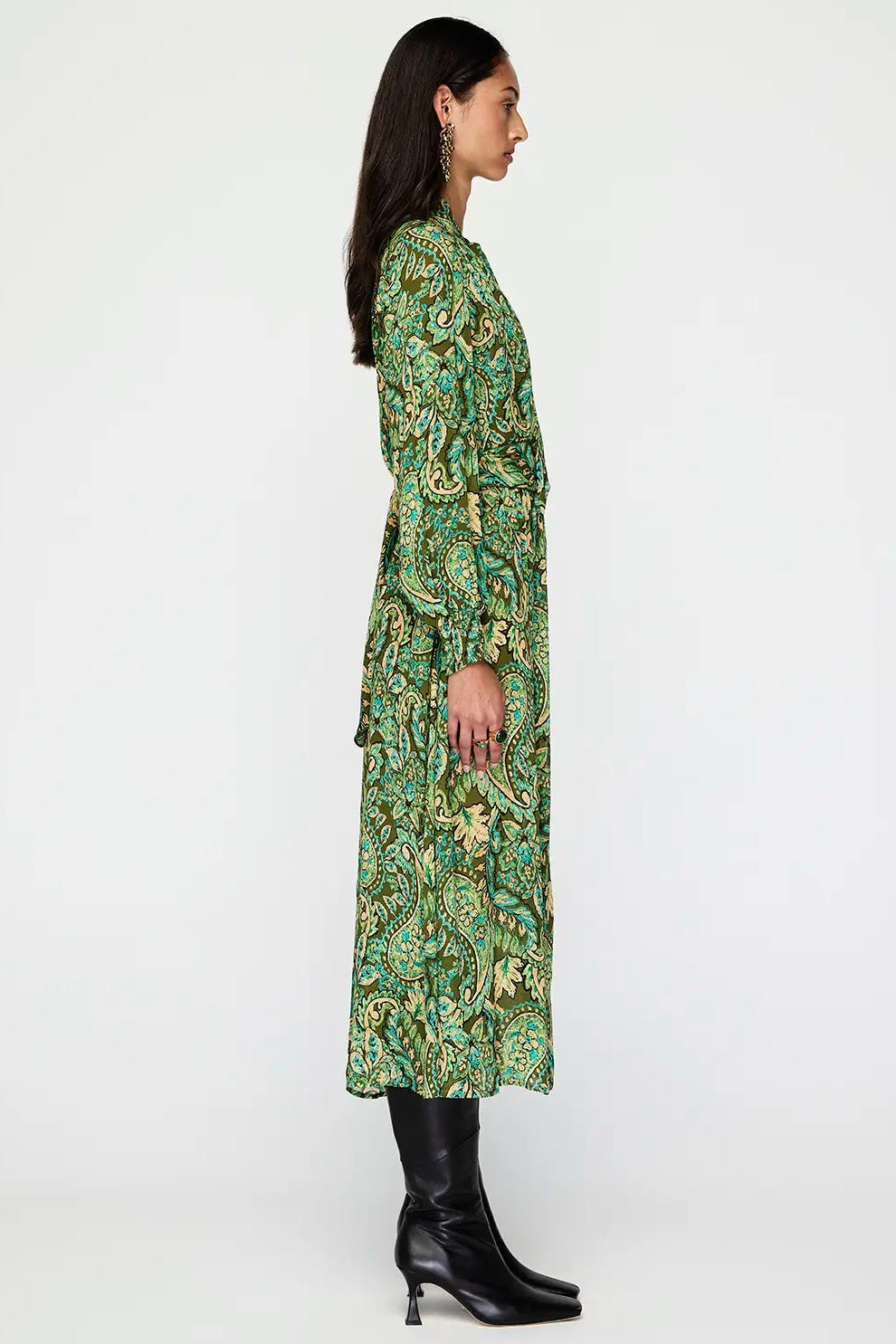 Woman wearing a green patterned dress on a white background