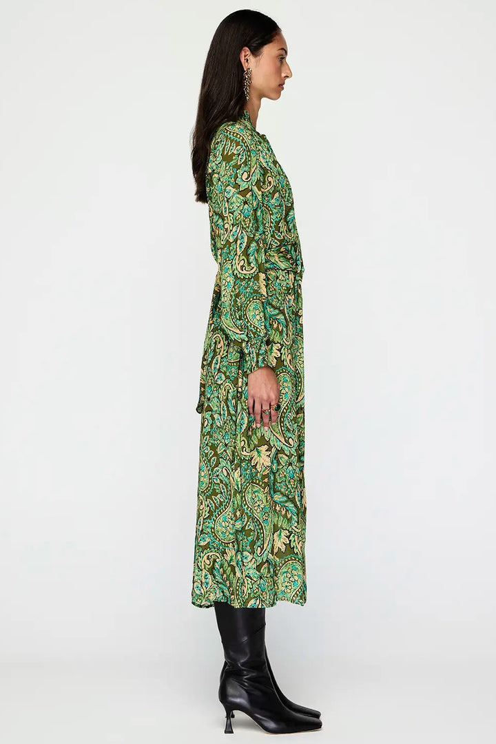 Woman wearing a green patterned dress on a white background