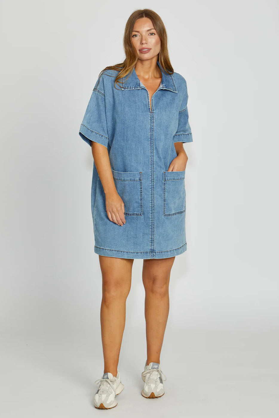 Woman wearing a denim dress on a white background