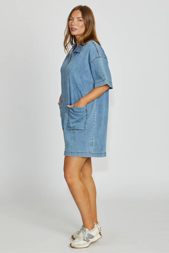 Woman wearing a blue denim dress on a white background