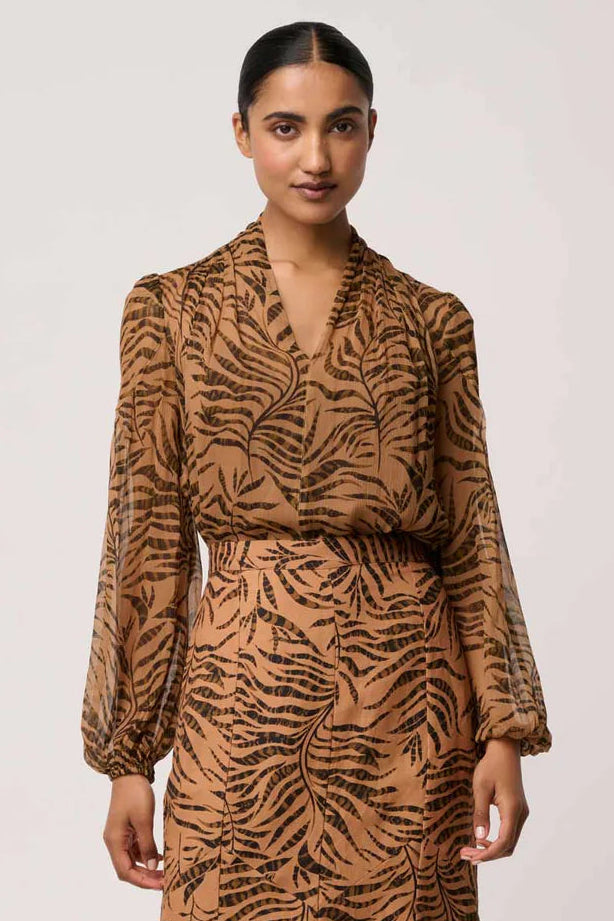 Woman wearing a brown animal print dress with matching boots on a white background