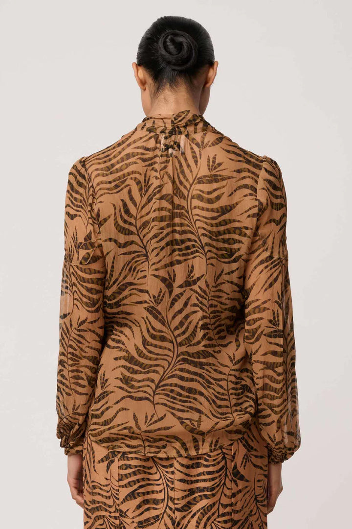 Person wearing a brown tiger pattern dress on a white background