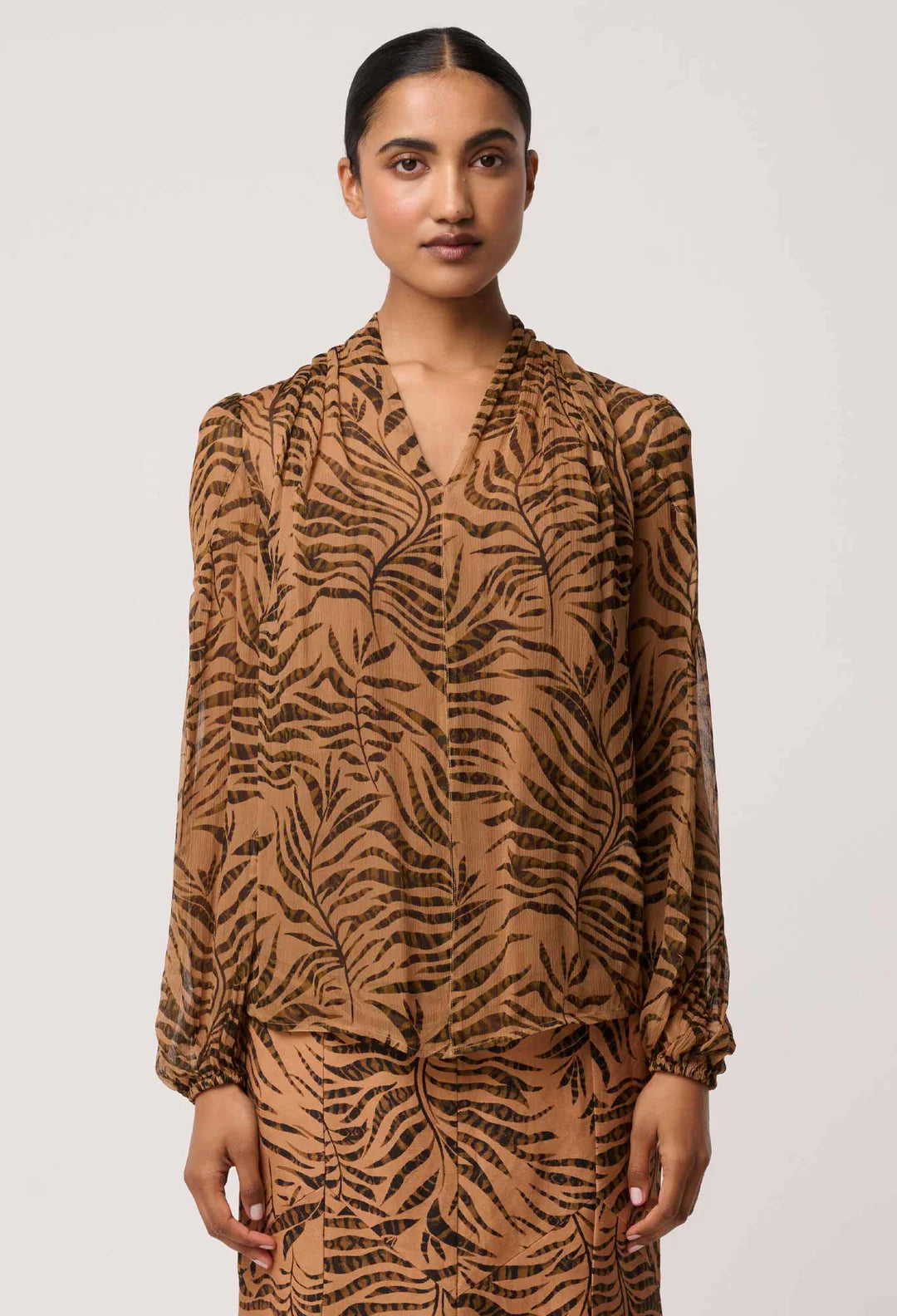Woman wearing a brown tiger pattern dress against a white background