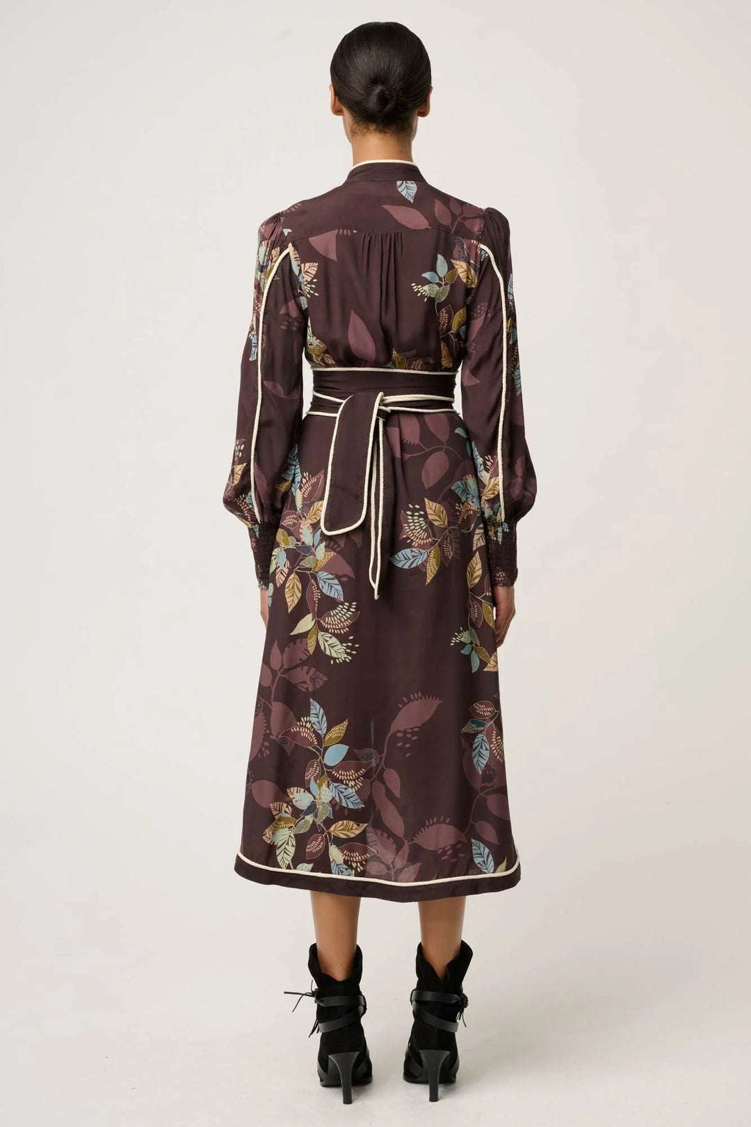 Woman wearing a floral dress with a belt on a white background