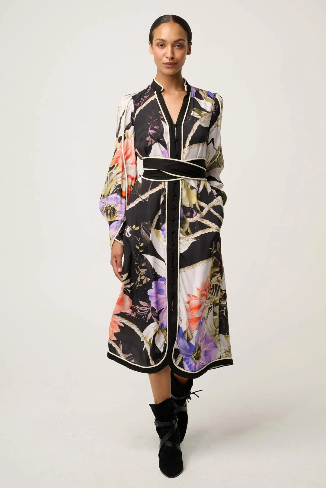 Woman wearing a floral dress with a belt on a white background