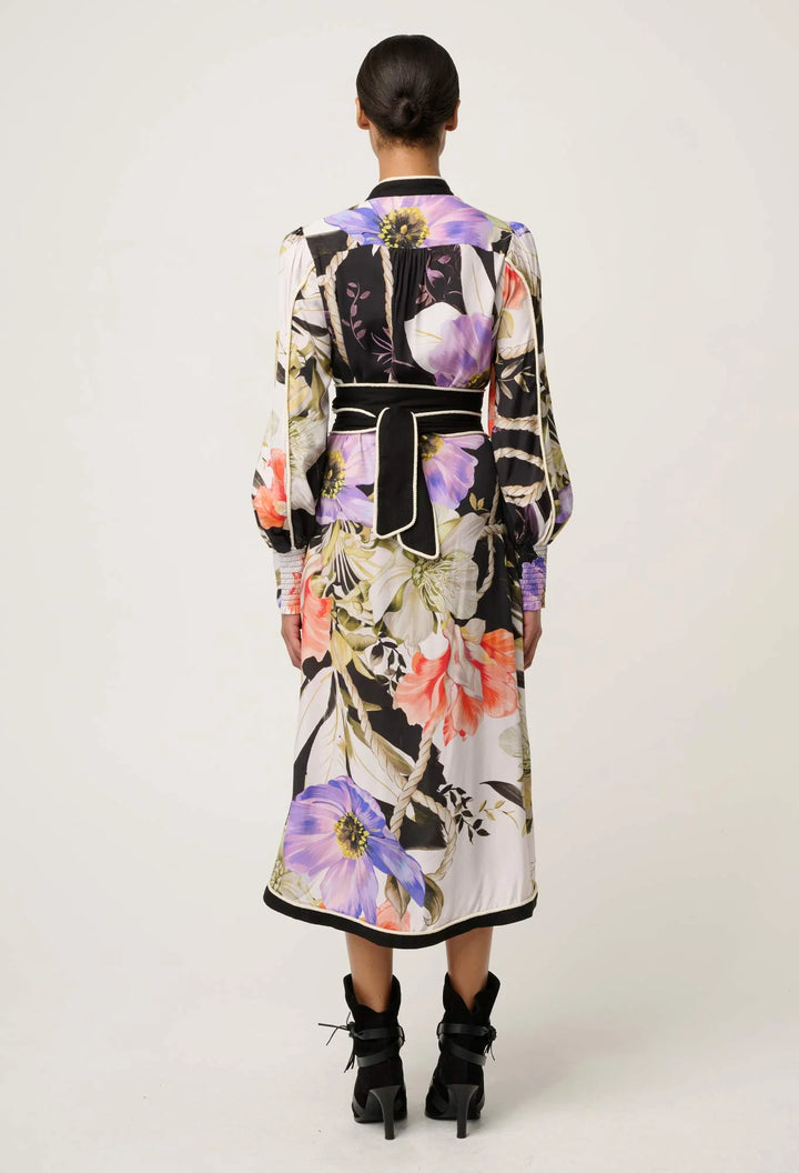 Person wearing a long, floral-patterned dress on a white background