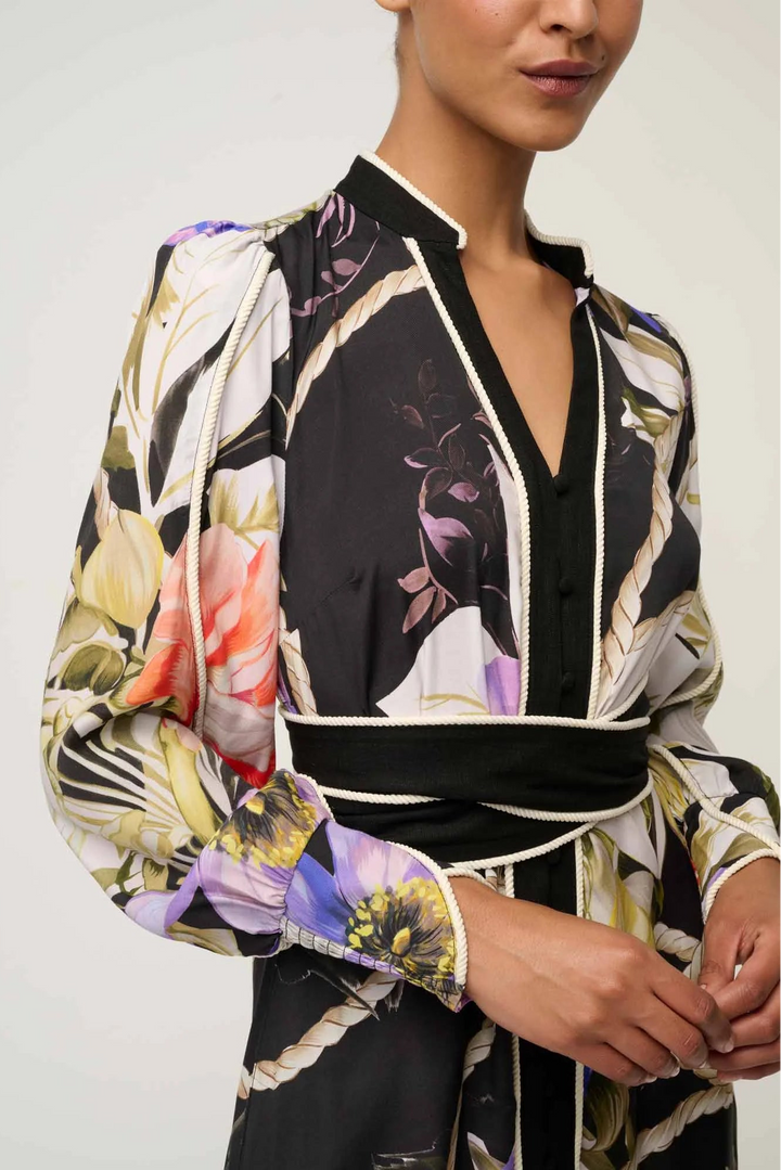 Woman wearing a floral patterned blouse with a plain background